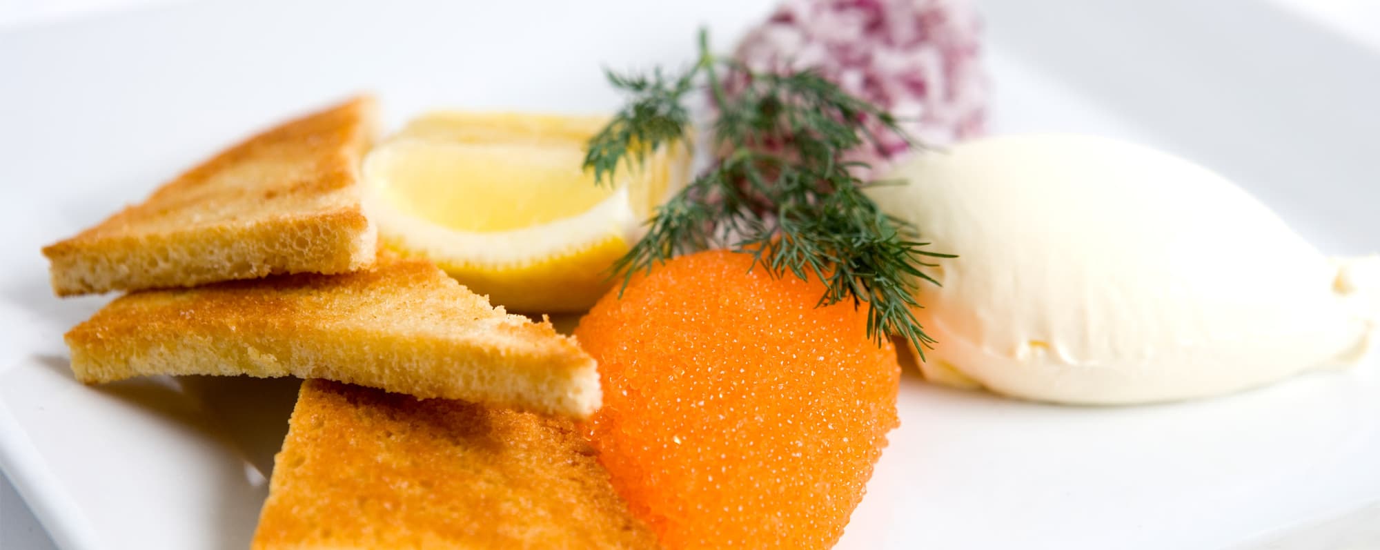 Prova mat och mousserande. En klick löjrom toppad med hackad rödlök och dill.