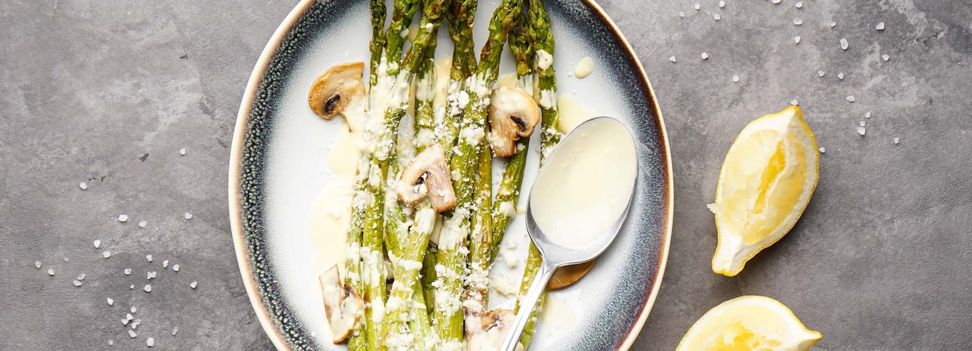 Gröns sparris med riven parmesan på rund tallrik