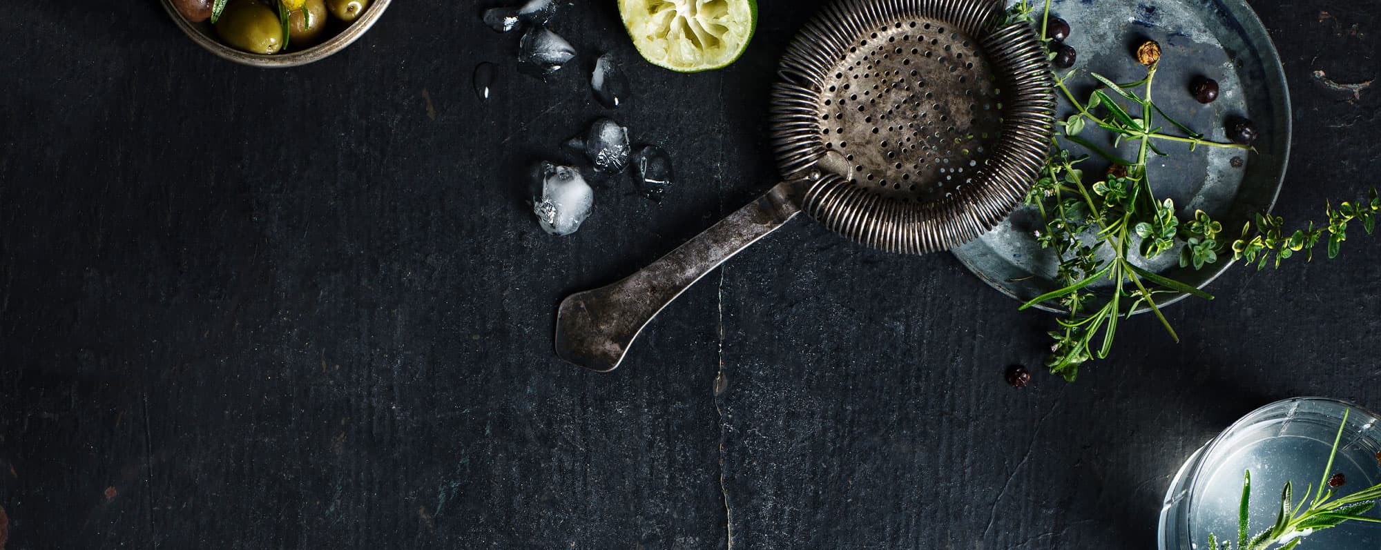 Alkoholfri gin och tonic: Shakersil omgiven av isbitar och kryddgrönt.