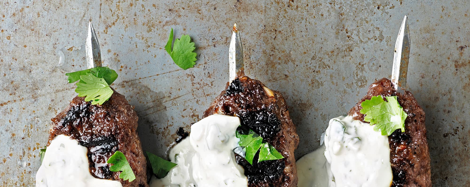 Närbild på souvlaki-spett med tsatsiki.