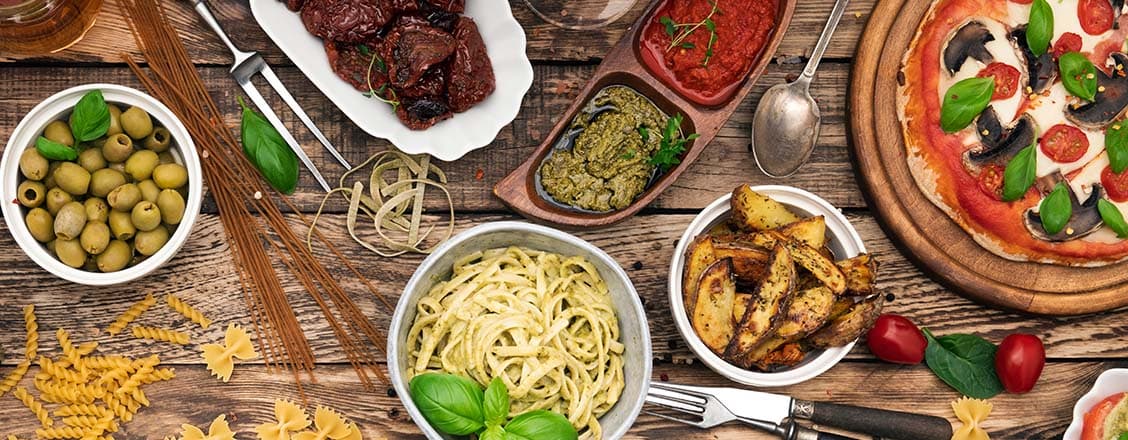 Olika italienska maträtter på ett träbord - buffé