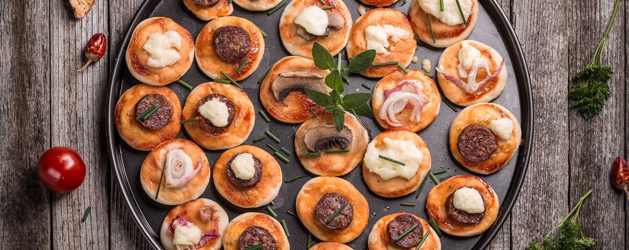 Minipizzor med olika slags topping igger på uppläggningsfat