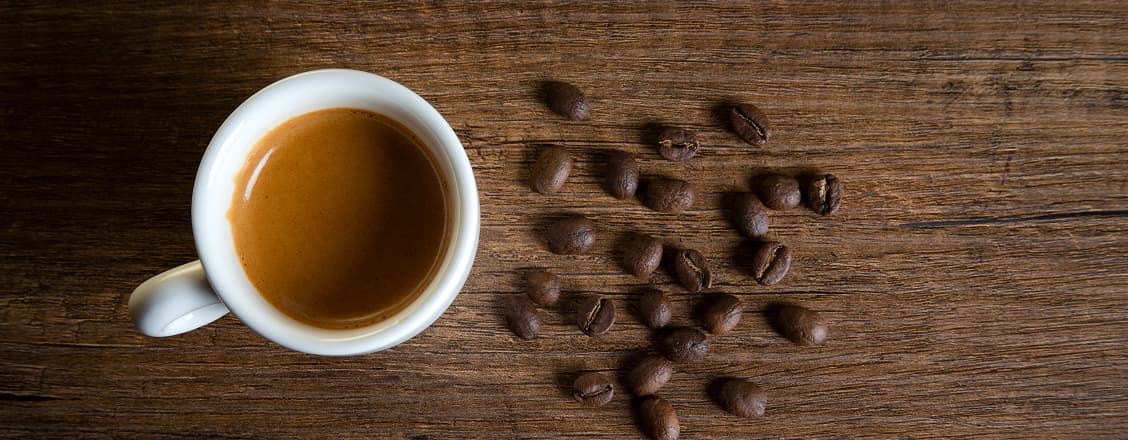 Kopp espresso och kaffebönor