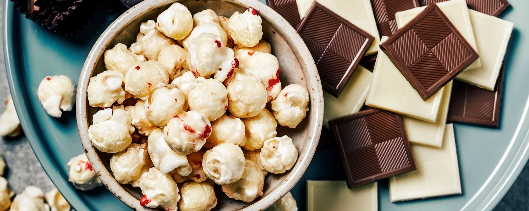 Skål med popcorn och choklad runt om