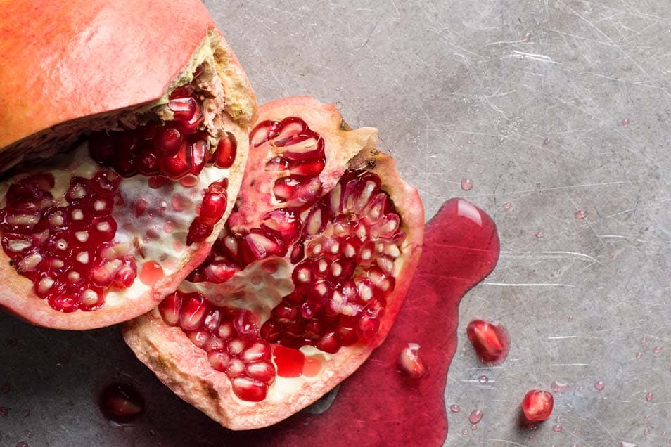 Delat granatäpple på stenskiva