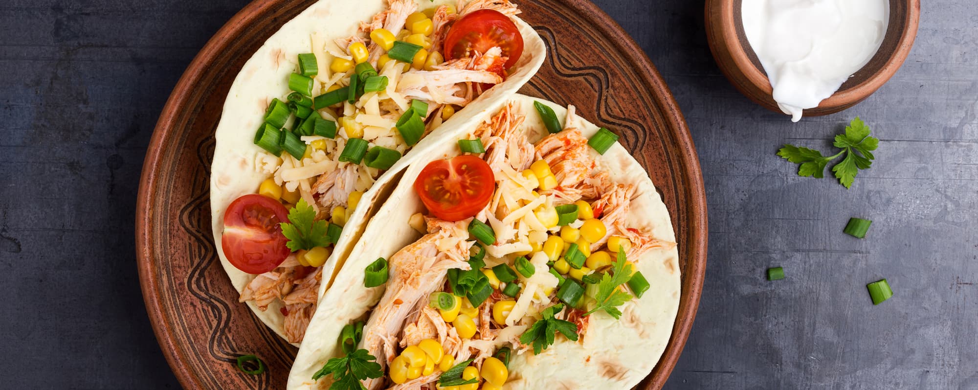 Mexikansk mat: Två tortillla fyllda med kycklingkött, tomat, majskorn och hackad lök.