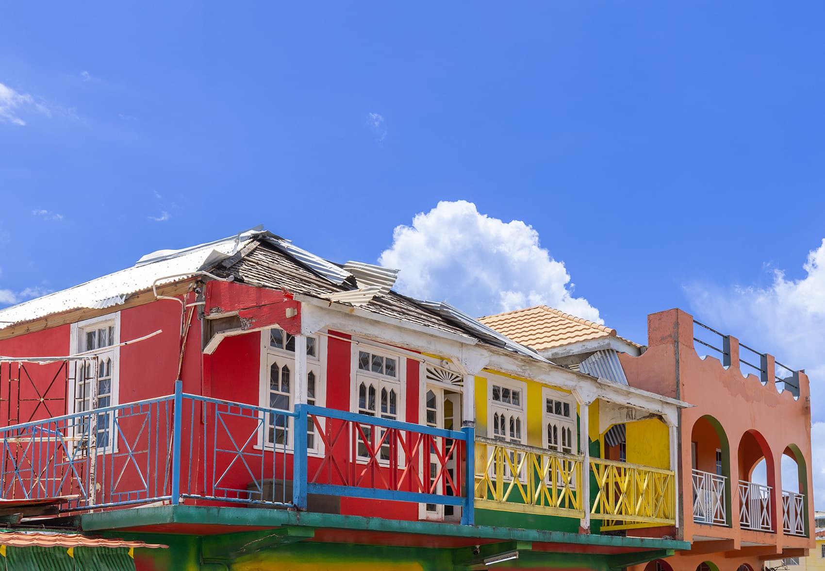 Rött, gult och rosa hus på Jamaica, blå himmel