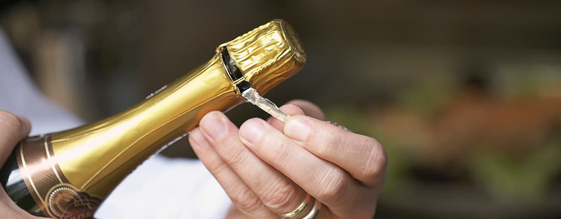 somelier öppnar en flaska champagne