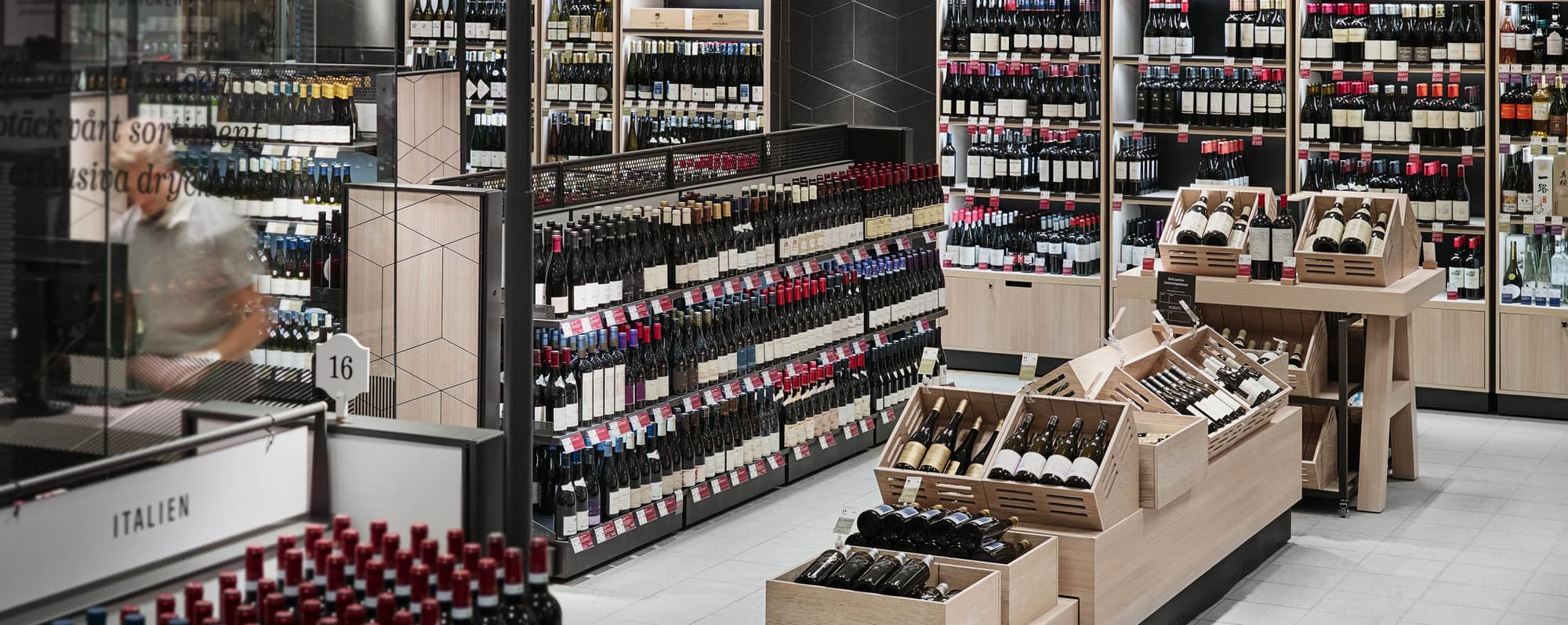 Välfyllda vinrödvinshyllor i en Systembolagsbutik.